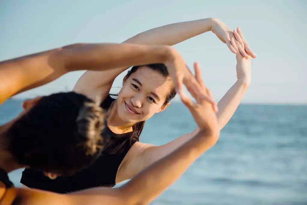 friends-doing-exercises-on-beach-G9AKBYW.jpg